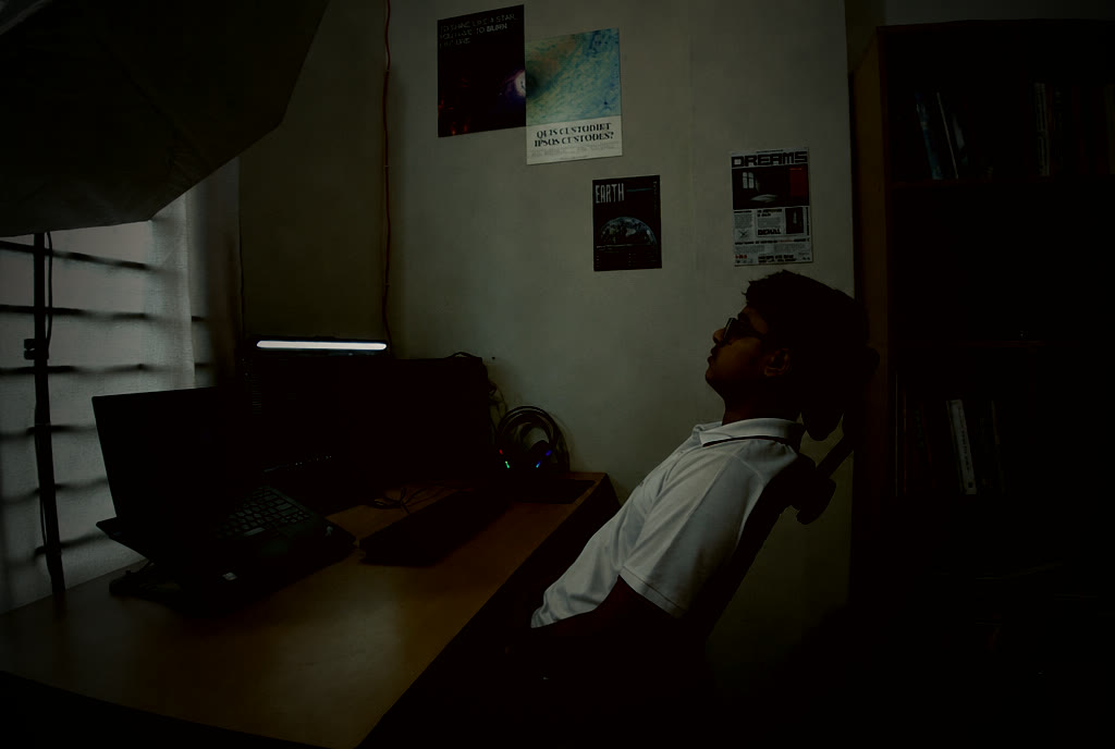 Sahol resting in the tilted chair at his real desk, screens still glowing